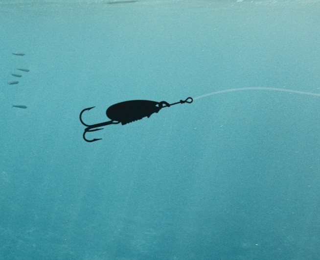 A fishing lure silhouette being trolled in the ocean